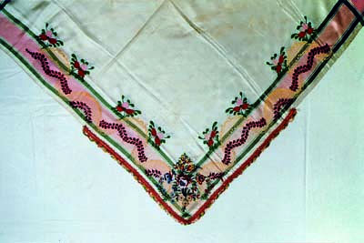 Viereckiges Halstuch (Sidnlumpn), helle Seide broschiert und lanciert, Borte, um 1850, Lötschental. Das quadratische Tuch wurde über der Schulter ins Dreieck gelegt und gerollt, weshalb die Borte nur einen Teil des Tuchs einfasst, Sammlung Lötschentaler Museum.