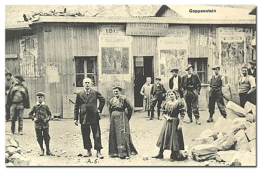 Ansichtskarte mit August Steiner, 1909-1913 Betreiber des Café International im Tunnelbaudorf Goppenstein. Neben Steiner stehen vermutlich seine Ehefrau und zwei seiner Kinder.